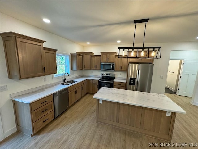 kitchen with stainless steel appliances, a sink, a kitchen island, hanging light fixtures, and brown cabinetry