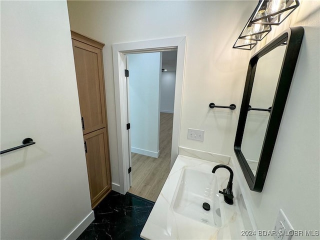 bathroom featuring marble finish floor, vanity, and baseboards