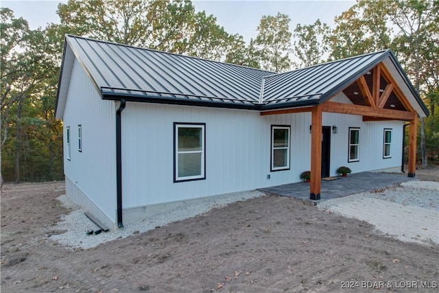 view of front of house featuring a standing seam roof, a patio area, and metal roof