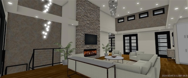 living room featuring a towering ceiling, hardwood / wood-style flooring, and a fireplace