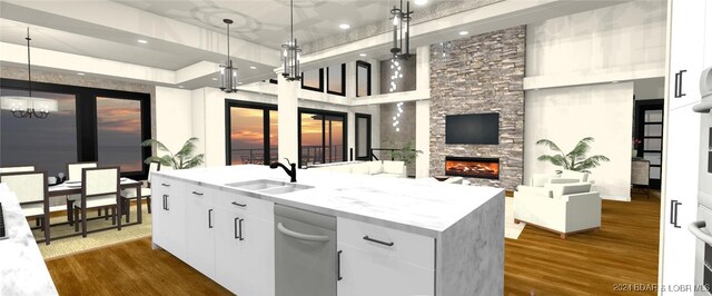 kitchen featuring white cabinets, dark wood-type flooring, a fireplace, pendant lighting, and sink