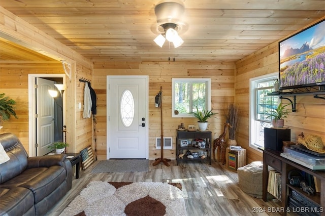 foyer entrance featuring ceiling fan, wood ceiling, wooden walls, and hardwood / wood-style floors