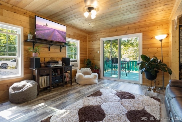 interior space with wood ceiling, wooden walls, wood-type flooring, and ceiling fan