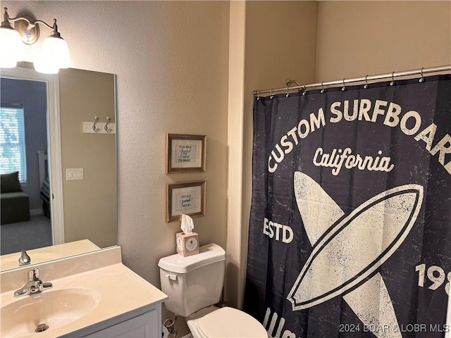 bathroom with curtained shower, vanity, and toilet