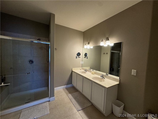 bathroom with tile patterned flooring, vanity, and a shower with door