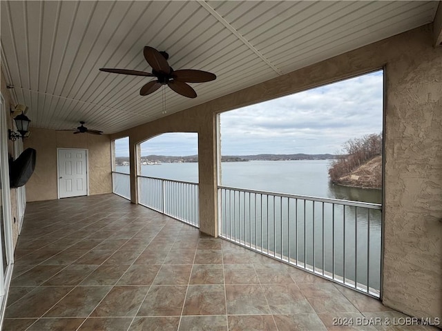 view of patio / terrace featuring a water view, ceiling fan, and a balcony