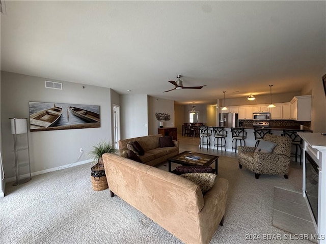 carpeted living room featuring ceiling fan