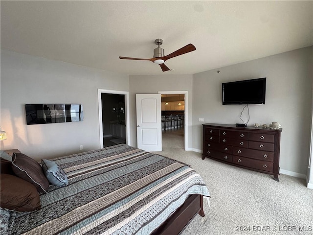 bedroom featuring ensuite bath, ceiling fan, and light colored carpet