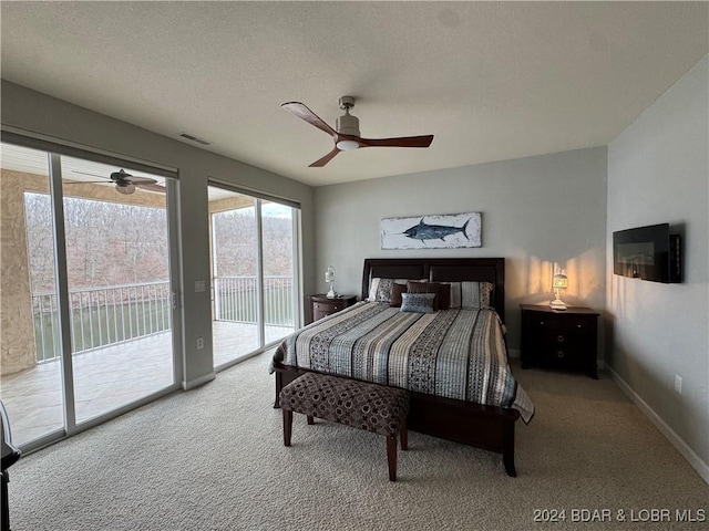 carpeted bedroom featuring access to exterior, a textured ceiling, and ceiling fan