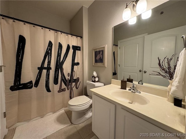 bathroom featuring tile patterned floors, curtained shower, vanity, and toilet