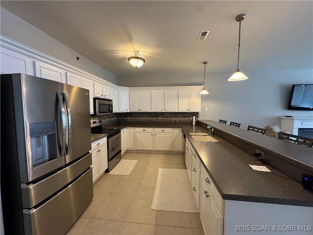 kitchen with white cabinetry, sink, hanging light fixtures, tasteful backsplash, and appliances with stainless steel finishes