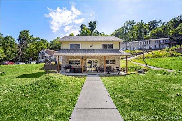 rear view of house with a patio and a yard