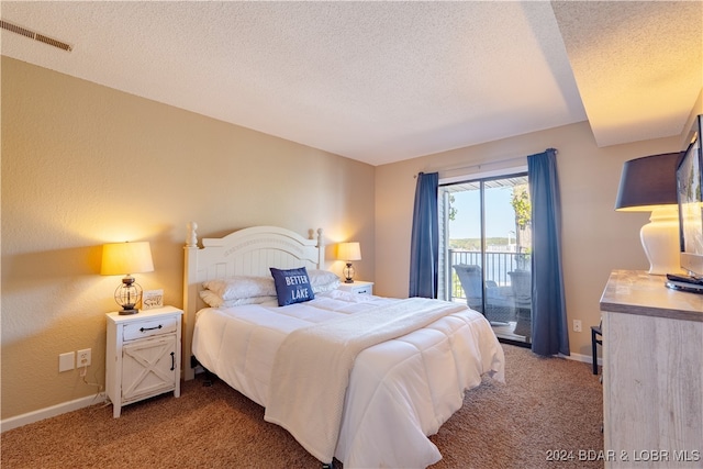 carpeted bedroom featuring a textured ceiling and access to exterior