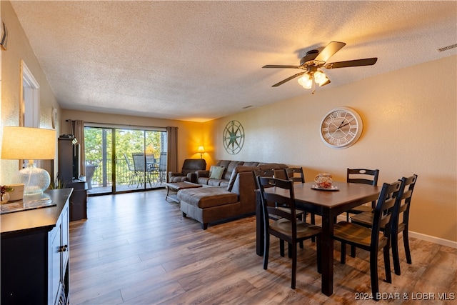 dining space with wood-type flooring, a textured ceiling, and ceiling fan