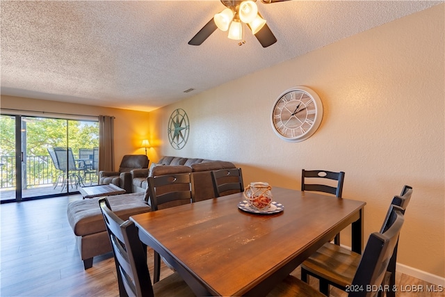 dining area with hardwood / wood-style flooring, ceiling fan, and a textured ceiling