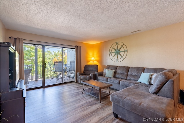 living room with hardwood / wood-style flooring and a textured ceiling