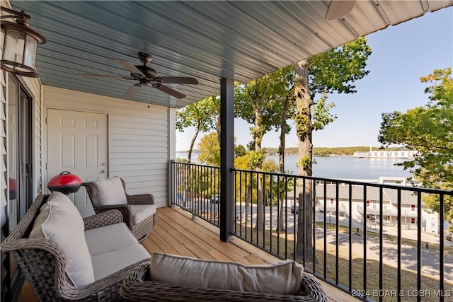 balcony featuring a water view and ceiling fan