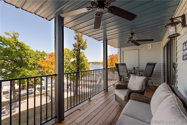 deck with a water view and ceiling fan