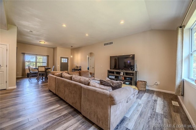 living room featuring dark hardwood / wood-style flooring and vaulted ceiling