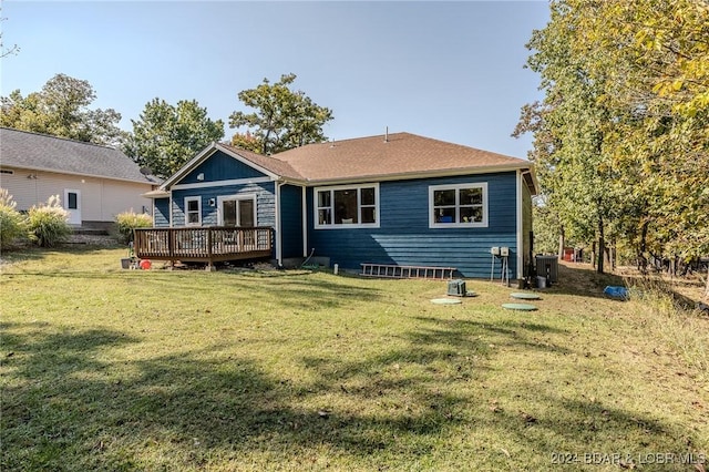 back of house with central AC unit, a lawn, and a wooden deck