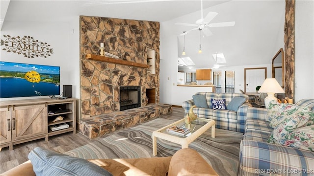 living room featuring ceiling fan, wood-type flooring, lofted ceiling, and a fireplace