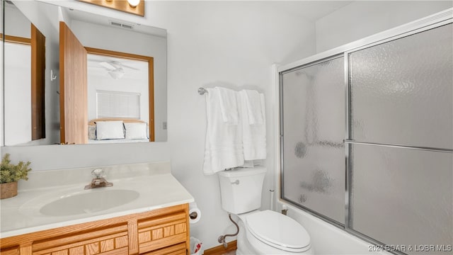 full bathroom featuring ceiling fan, vanity, enclosed tub / shower combo, and toilet