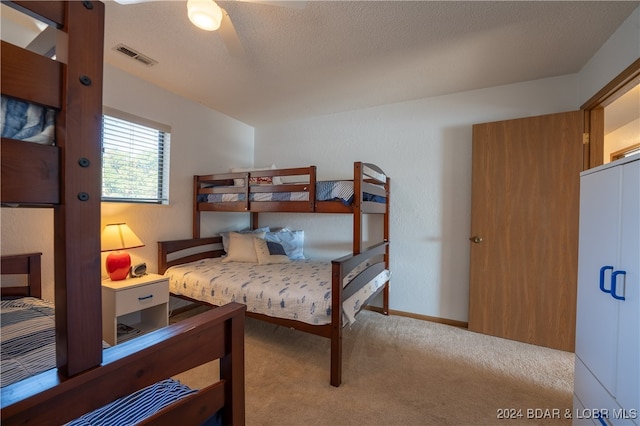 carpeted bedroom with a textured ceiling and ceiling fan