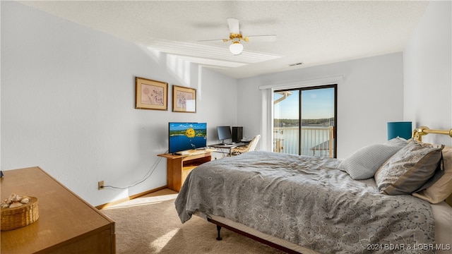 carpeted bedroom featuring access to exterior, ceiling fan, and a textured ceiling