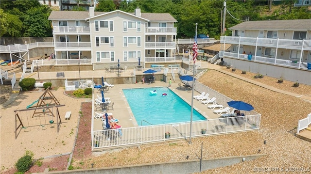 community pool with a patio and fence