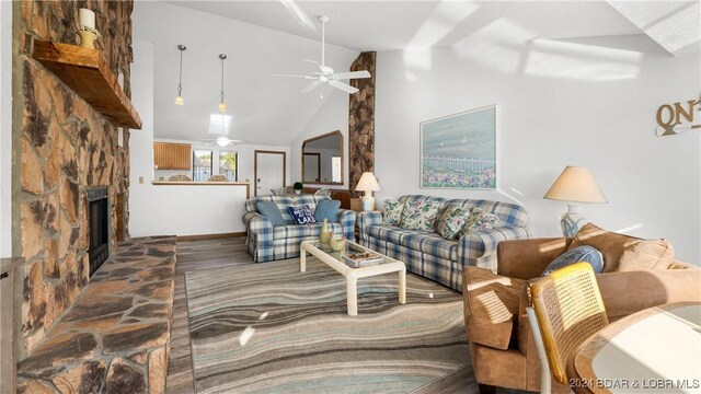 living area featuring a fireplace, ceiling fan, high vaulted ceiling, baseboards, and wood finished floors