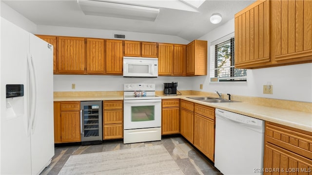 kitchen featuring lofted ceiling, sink, beverage cooler, and white appliances