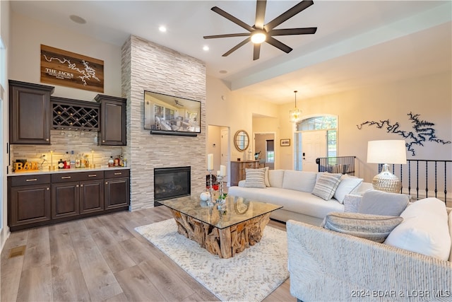 living room featuring a fireplace, light hardwood / wood-style flooring, and ceiling fan