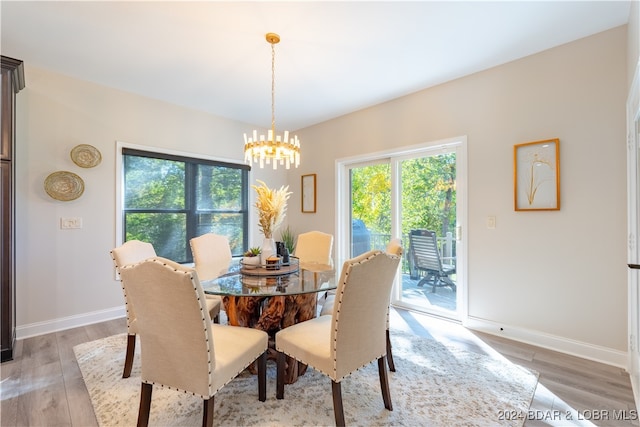 dining area with wood-type flooring and a notable chandelier