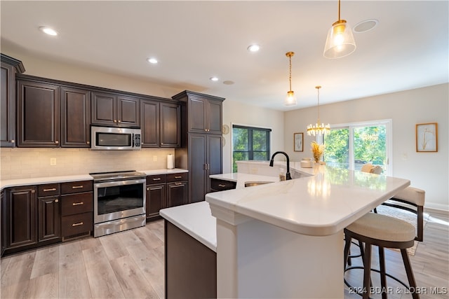 kitchen with a large island, appliances with stainless steel finishes, sink, and a breakfast bar