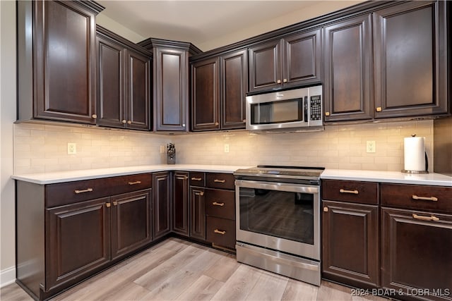 kitchen featuring dark brown cabinets, stainless steel appliances, decorative backsplash, and light hardwood / wood-style flooring