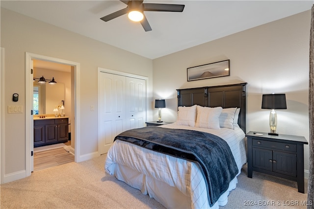 carpeted bedroom with ensuite bath, ceiling fan, and a closet