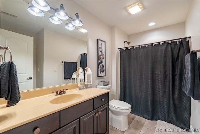 bathroom featuring hardwood / wood-style flooring, toilet, and vanity