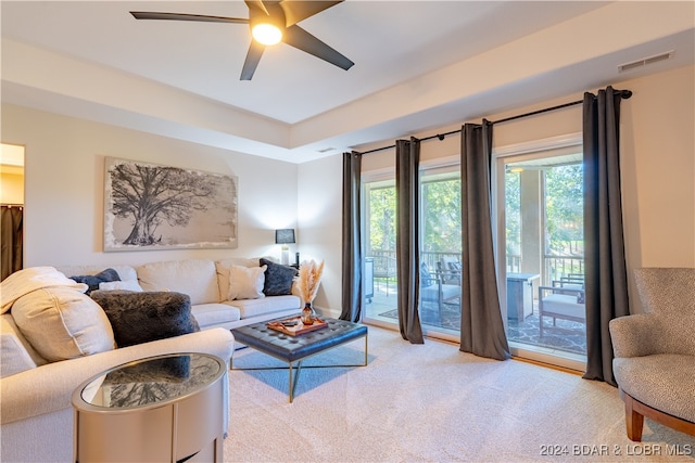 carpeted living room with ceiling fan