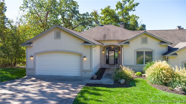 ranch-style house with a garage and a front lawn