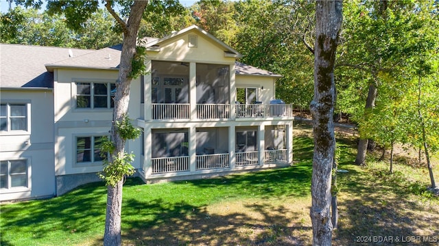 back of house featuring a yard and a sunroom