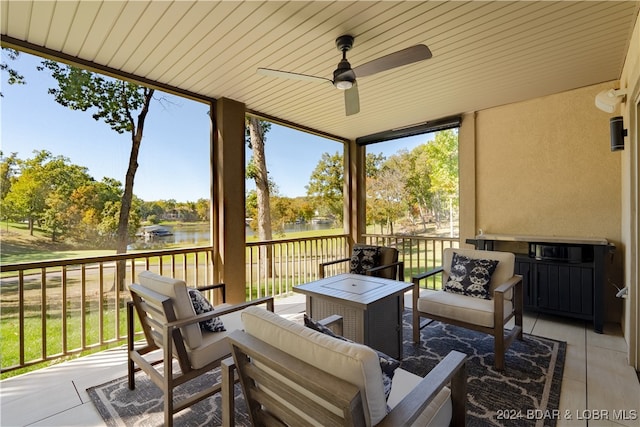 sunroom with ceiling fan, wood ceiling, plenty of natural light, and a water view