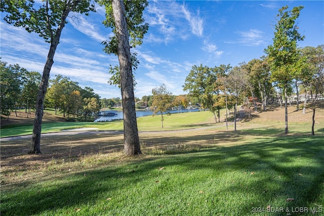 view of property's community with a lawn and a water view