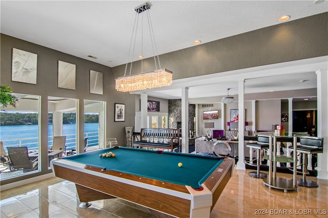 game room featuring billiards, tile patterned flooring, a water view, and a high ceiling