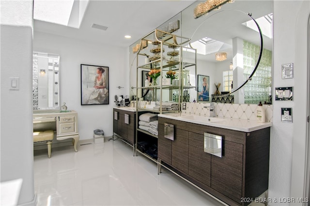 bathroom featuring a skylight, vanity, and tile patterned flooring