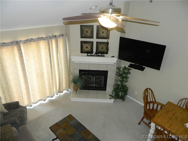 living room with ceiling fan, a tile fireplace, and carpet flooring