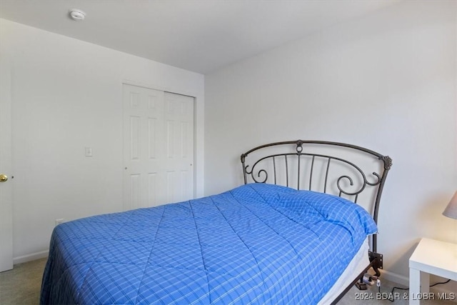 bedroom with carpet floors, a closet, and baseboards