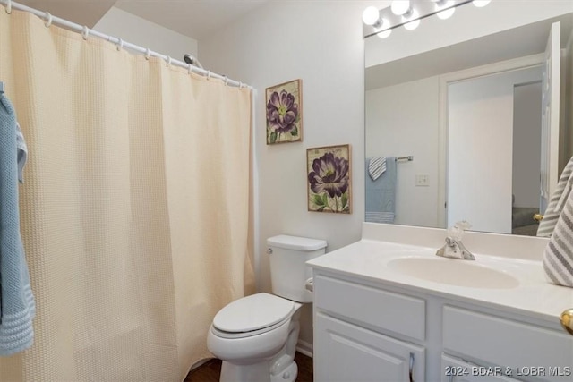 full bath with curtained shower, vanity, and toilet