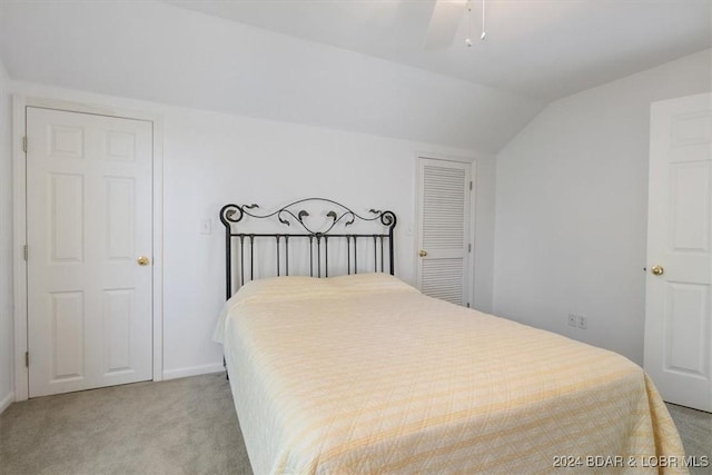 bedroom with vaulted ceiling, a ceiling fan, and light colored carpet