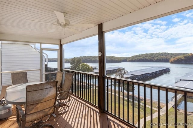 exterior space with ceiling fan, outdoor dining space, and a water view