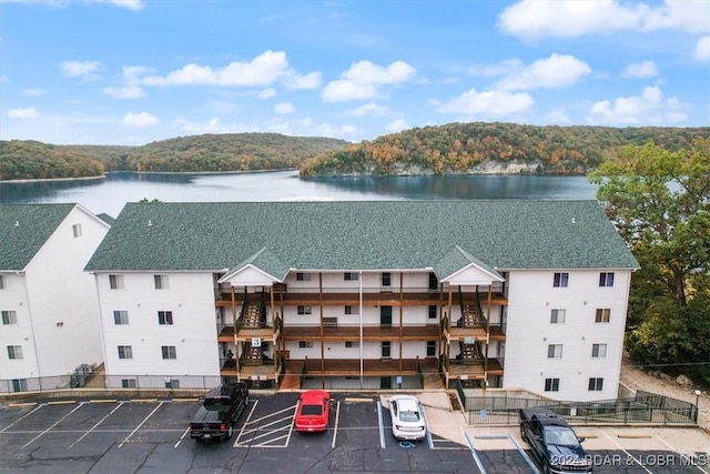 aerial view of a large body of water, a heavily wooded area, and apartment complex